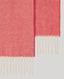 Pink scarf with beige fringe on a light gray background