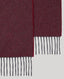 Close up on fringe detail on a deep red scarf