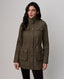 A woman modeling a mid-length olive green tweed jacket with a subtle red windowpane check pattern, featuring a high stand collar, button front, and flap pockets, set against a plain light gray studio background.
