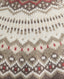 Close-up of a knitted sweater pattern with a Fair Isle design in cream, taupe, brown, and red.
