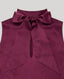 Close-up on tie neck detail on silk sleeveless blouse in aubergine purple 
