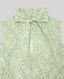 Close-up on tie neck detail on Green paisley patterned sleeveless blouse on a light grey background