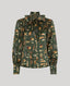 A long-sleeve blouse with a high collar and front tie, featuring an all-over feather print in olive green, brown, beige, and rust tones, shown on a solid gray background.