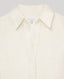 Close-up of a collared button-front shirt in a warm off-white or cream tone, with a visible neck label reading REALLY WILD.