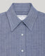Close-up of a blue textured collared button-down shirt with a visible neck label reading 'REALLY WILD x A.W. Wills'.