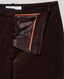 Close-up of dark brown corduroy trousers showing the interior lining with a contrasting orange-brown edge and a visible 'REALLY WILD' brand label.