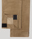 Close-up of tan corduroy pants folded to show velcro cuffs, against a light gray background.