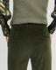 Close-up of Back of model wearing Wellington Corduroy Flare Trousers in Dark Olive Green