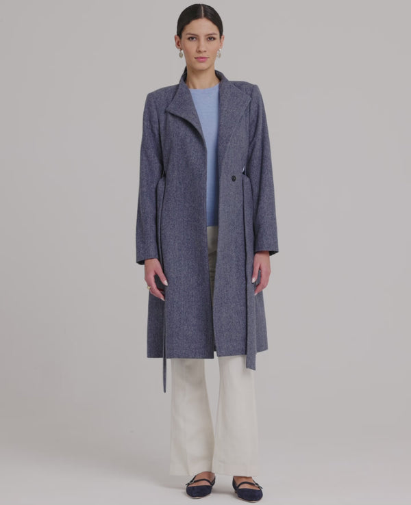 Model wearing the Louise Herringbone Funnel Wool Coat in blue—a sophisticated outerwear piece featuring classic tailoring with a contemporary twist. Video view of the coat.